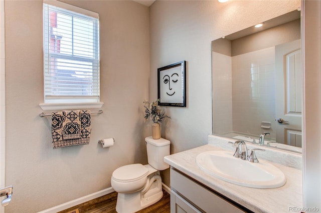 bathroom featuring vanity, wood finished floors, a shower, toilet, and baseboards