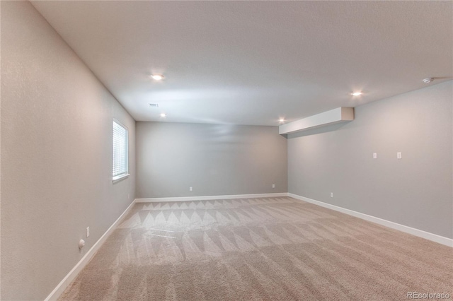 basement featuring recessed lighting, baseboards, and light colored carpet