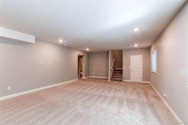 below grade area featuring visible vents, light colored carpet, stairs, baseboards, and recessed lighting