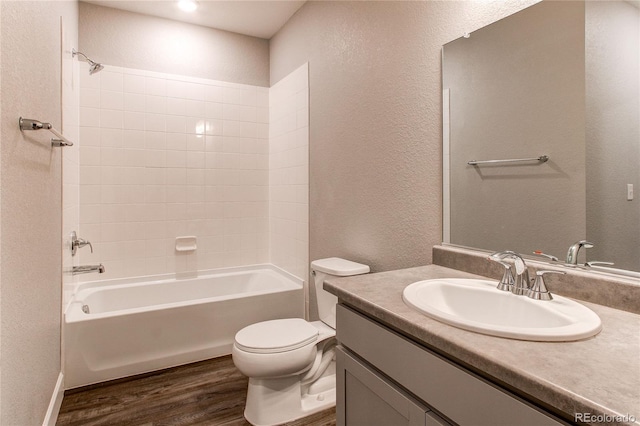 bathroom with vanity, a textured wall, wood finished floors, and toilet