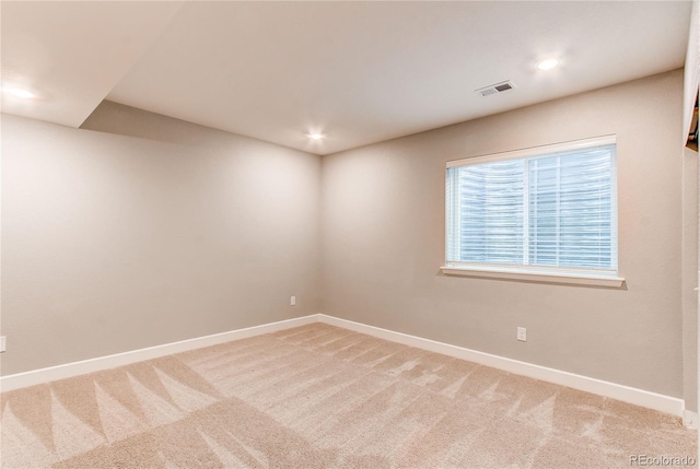 empty room with light colored carpet, baseboards, and visible vents