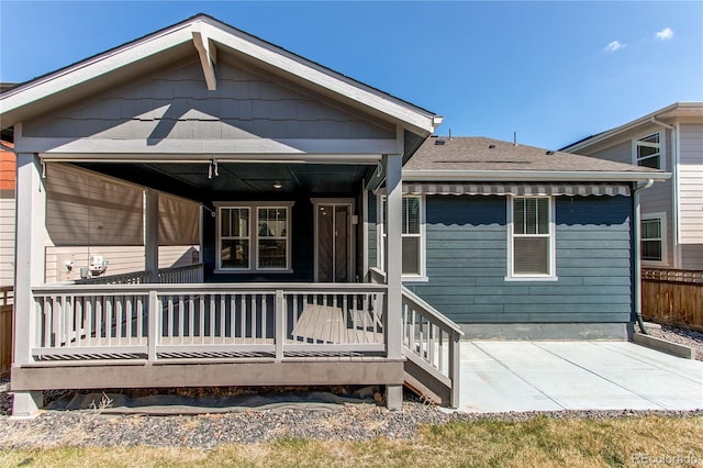 rear view of house with a patio and a shingled roof