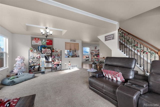 carpeted living room with crown molding, a raised ceiling, and a notable chandelier