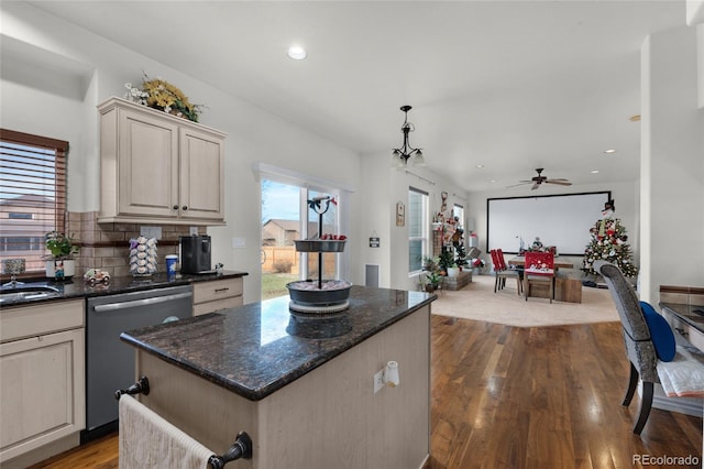 kitchen featuring a kitchen island, decorative light fixtures, tasteful backsplash, dishwasher, and wood-type flooring