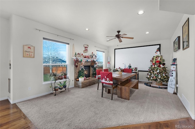 office area featuring a wealth of natural light, a fireplace, ceiling fan, and hardwood / wood-style flooring