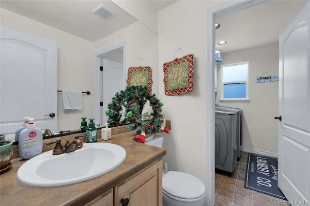 bathroom with vanity, independent washer and dryer, and toilet