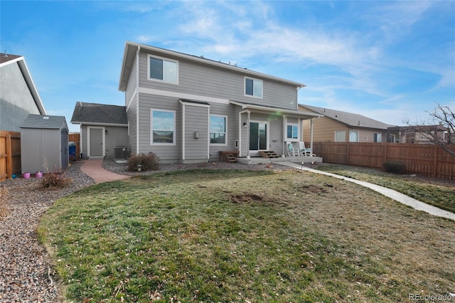 back of property with a yard and a storage unit