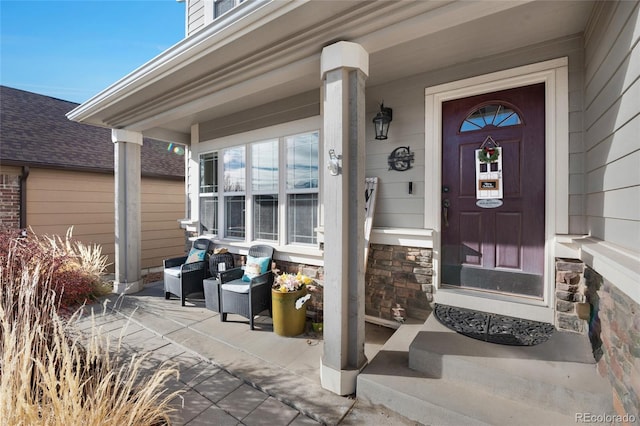 view of exterior entry featuring covered porch