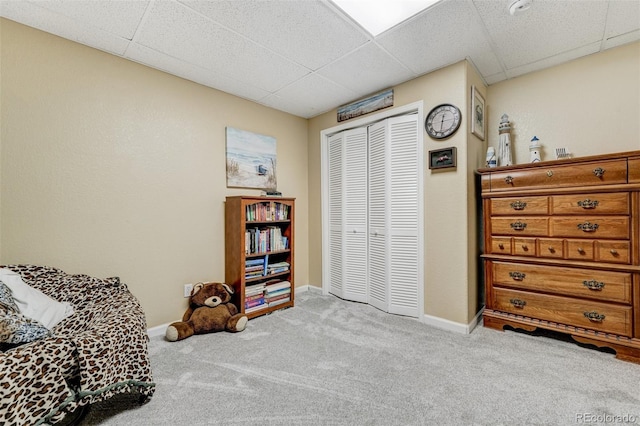 sitting room with a paneled ceiling and light colored carpet