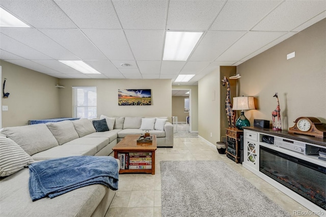 living room with a drop ceiling and light tile patterned floors