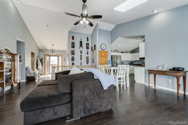 living room featuring dark wood-type flooring, a skylight, high vaulted ceiling, and ceiling fan