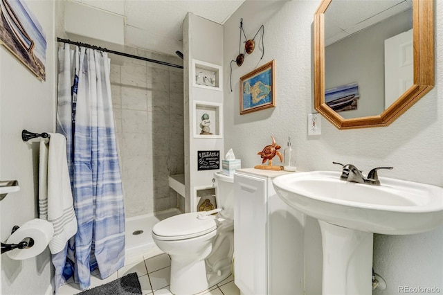 bathroom featuring sink, curtained shower, tile patterned floors, and toilet