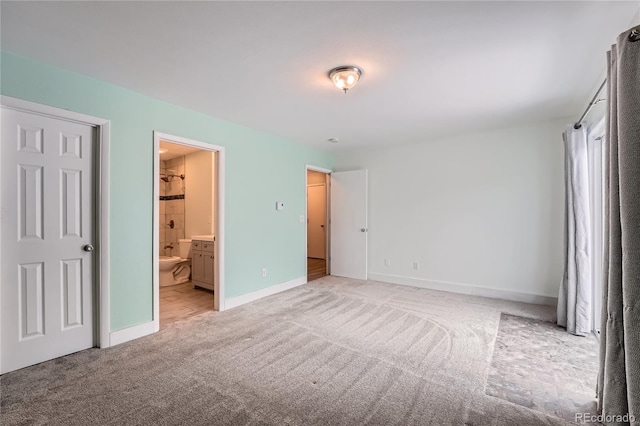 unfurnished bedroom featuring ensuite bath, baseboards, and light colored carpet