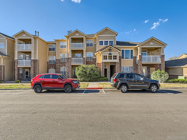 5755 N Genoa Way Unit 14-105, Aurora, CO 80019 - view of property with brick siding and uncovered parking