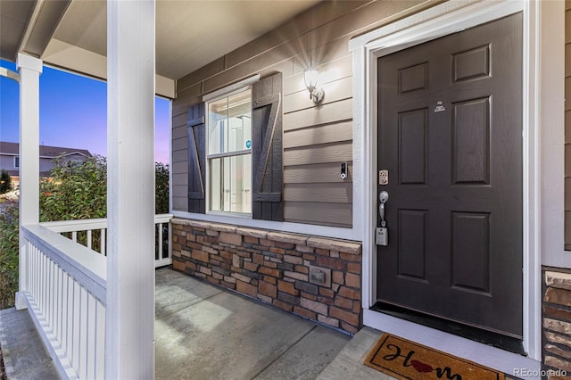 exterior entry at dusk featuring a porch