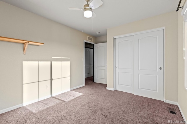 unfurnished bedroom featuring carpet floors, a closet, and ceiling fan