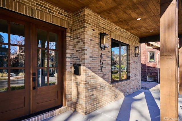 view of exterior entry with french doors and a porch