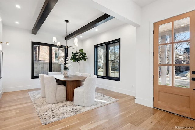 dining space featuring a wealth of natural light, beamed ceiling, and light hardwood / wood-style floors