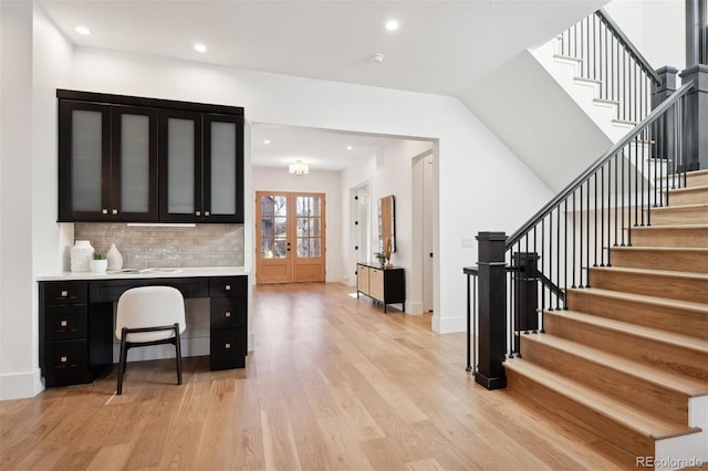 kitchen with decorative backsplash, french doors, and light hardwood / wood-style floors