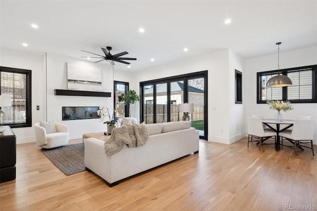 living room featuring light hardwood / wood-style flooring and ceiling fan