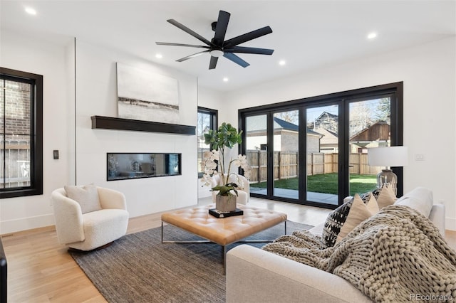 living room with ceiling fan and light wood-type flooring