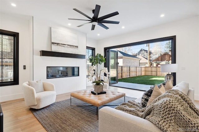 living room with ceiling fan and light hardwood / wood-style floors