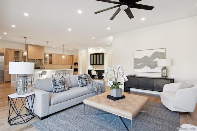 living room featuring ceiling fan and light wood-type flooring