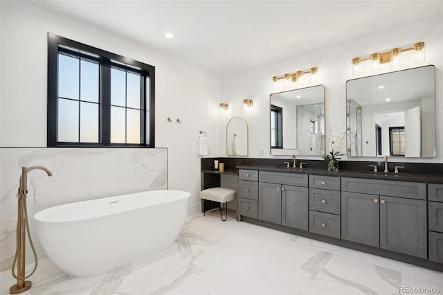 bathroom with a washtub, vanity, and tile walls