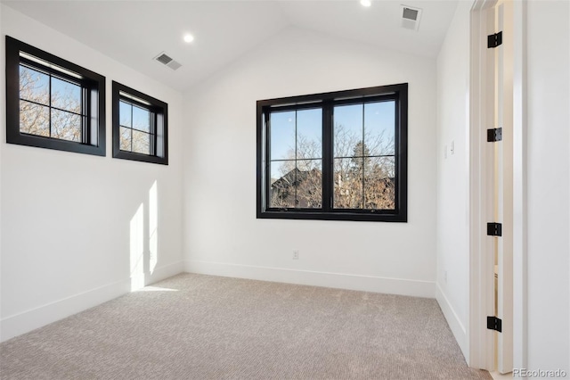 carpeted empty room with lofted ceiling