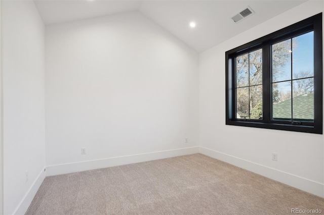 empty room with lofted ceiling and light carpet