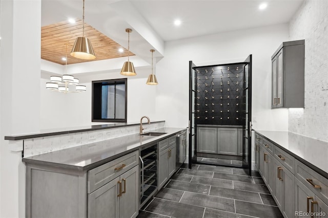 kitchen featuring gray cabinetry, wood ceiling, beverage cooler, sink, and pendant lighting