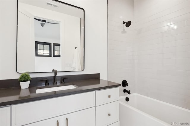 bathroom featuring tiled shower / bath combo and vanity