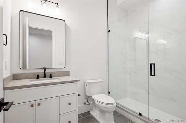 bathroom with tile patterned flooring, vanity, a shower with shower door, and toilet