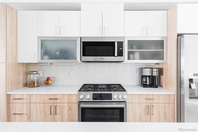 879 Delaware St, Denver, CO 80204 - kitchen featuring appliances with stainless steel finishes, modern cabinets, light countertops, and decorative backsplash