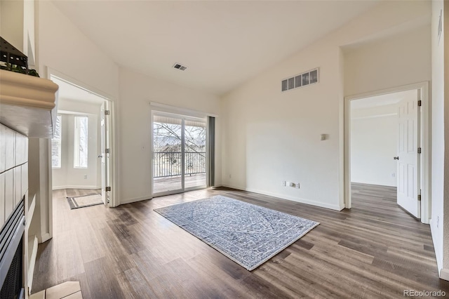 interior space featuring high vaulted ceiling, wood finished floors, and visible vents