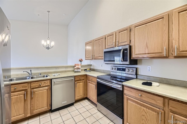 kitchen featuring a notable chandelier, light tile patterned floors, stainless steel appliances, light countertops, and a sink