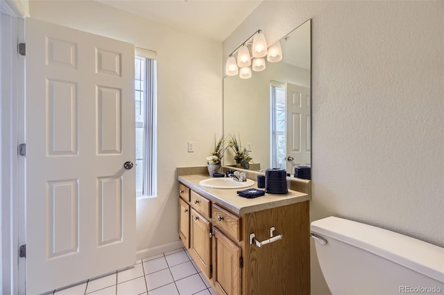 bathroom featuring toilet, vanity, baseboards, and tile patterned floors