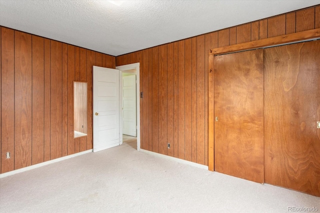 8005 W US Highway 50, Salida, CO 81201 - unfurnished bedroom with carpet floors, wood walls, baseboards, a textured ceiling, and a closet
