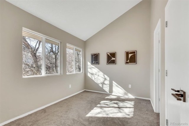unfurnished room featuring carpet floors, lofted ceiling, and baseboards