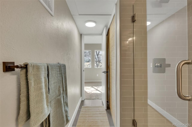 full bath with a textured wall, visible vents, and tiled shower