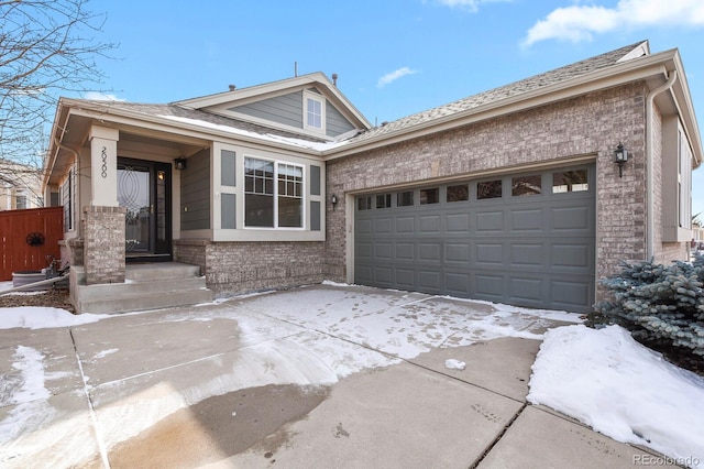 view of front facade with an attached garage, driveway, and brick siding