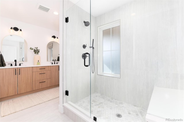 bathroom featuring vanity and a shower with door