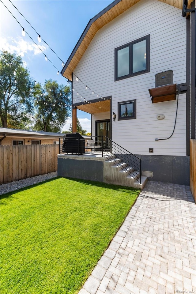 rear view of property featuring a lawn and a patio