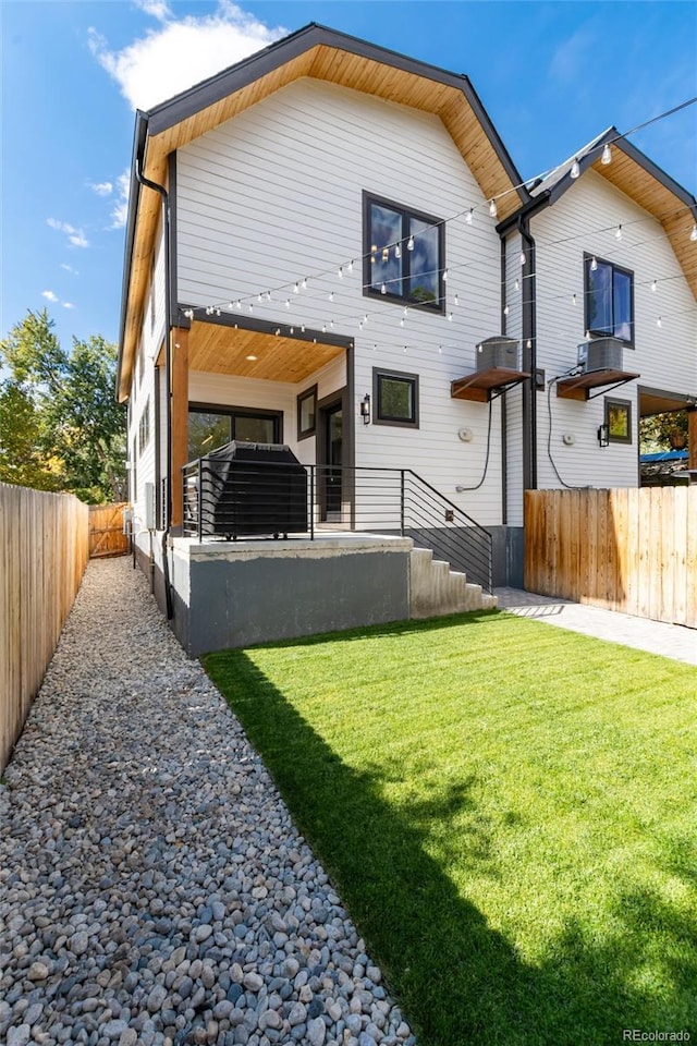 rear view of house featuring a lawn