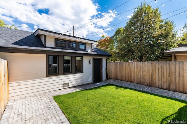 rear view of house featuring a lawn