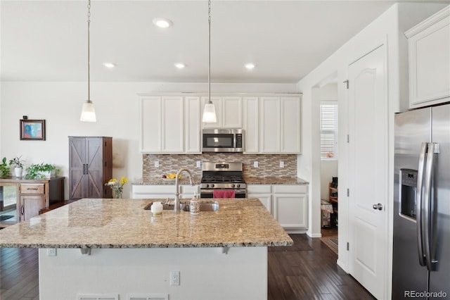 2682 E 161st Pl, Thornton, CO 80602 - kitchen featuring appliances with stainless steel finishes, a sink, dark wood finished floors, decorative backsplash, and white cabinetry