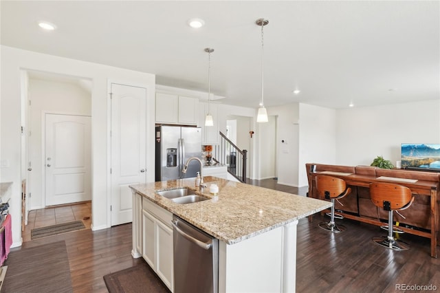 2682 E 161st Pl, Thornton, CO 80602 - kitchen featuring appliances with stainless steel finishes, a sink, dark wood-style flooring, a center island with sink, and white cabinets