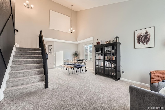 interior space with a towering ceiling, carpet floors, and an inviting chandelier