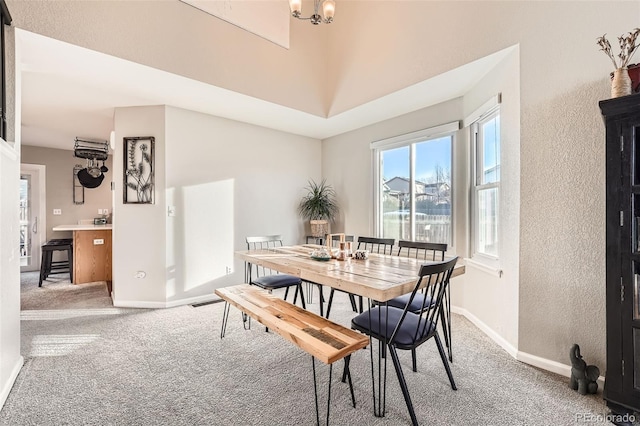 dining room featuring carpet flooring and a chandelier