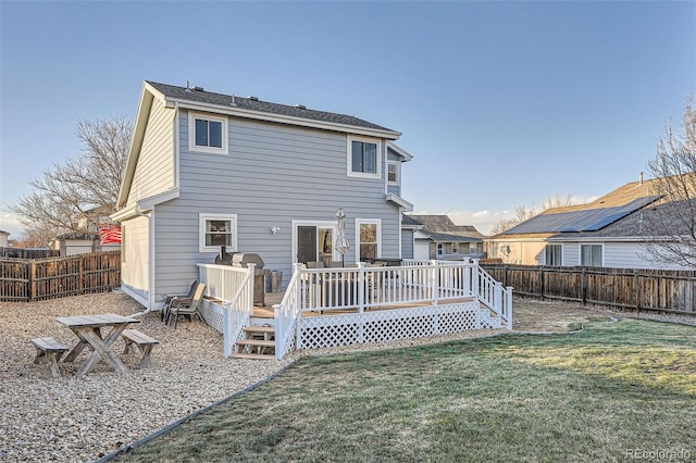 rear view of property featuring a yard and a wooden deck